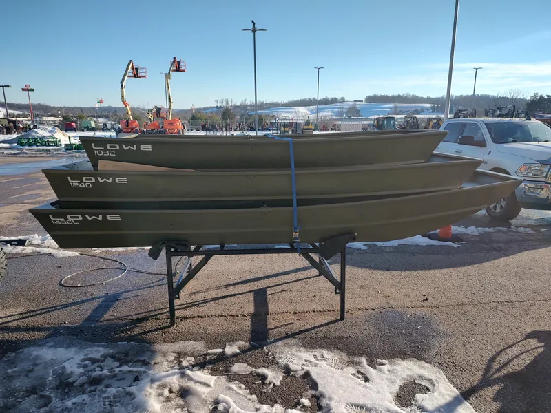 Slide: The Image of Stacked Lowe Jon L1436L boats on a stand in a snowy outdoor setting. - 4