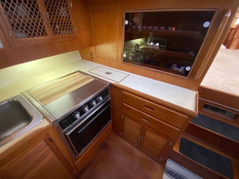 Slide: The Image of 1991 Lien Hwa McKinna 42 Aft Cabin kitchen with stove, sink, and wooden cabinetry. - 49