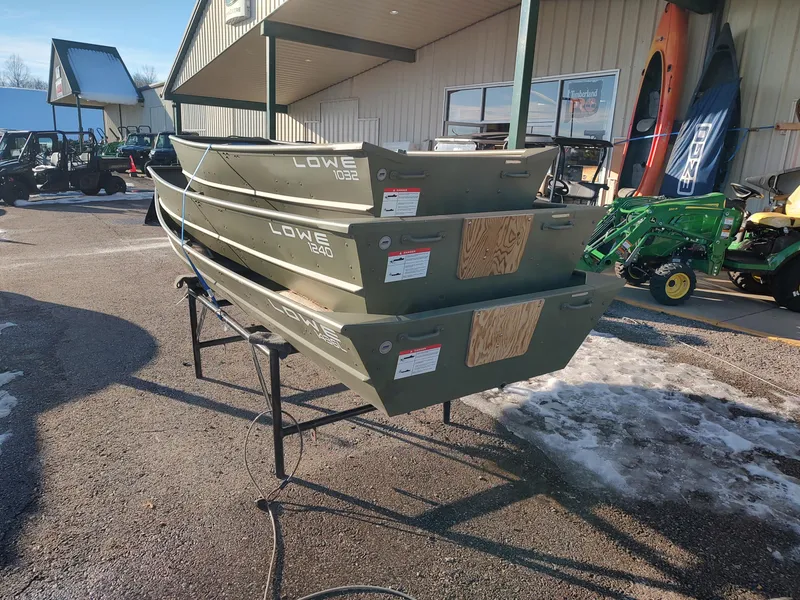 Slide: The Image of Stacked Lowe Jon L1240 boats, 2025 model, displayed outdoors on a sunny day. - 8