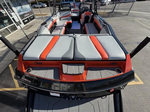 Slide: The Image of 2019 Axis A24 boat with orange and gray seating, parked outdoors. - 10