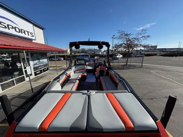 Slide: The Image of 2019 Axis A24 boat with red and gray seating, parked outside a dealership. - 11