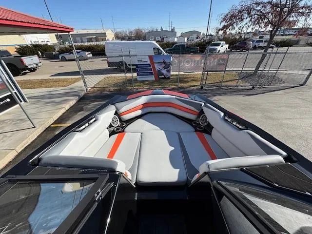 Slide: The Image of 2019 Axis A24 boat interior with gray and orange seating, parked outdoors. - 13
