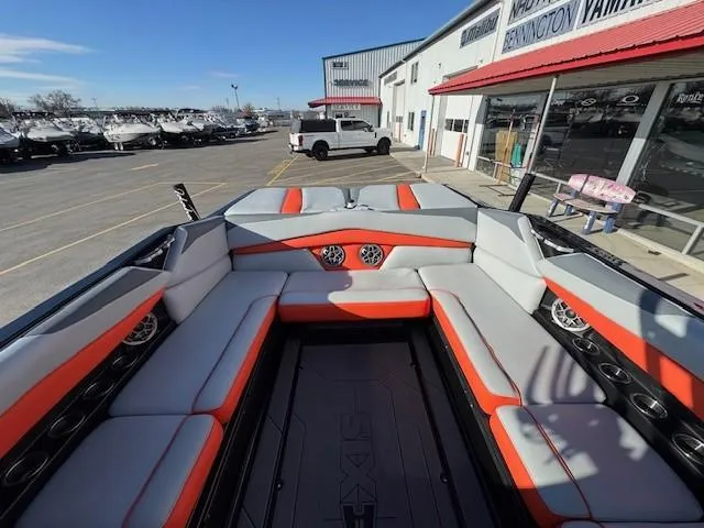 Slide: The Image of 2019 Axis A24 with red and grey seats, located at a dealership with other boats. - 15