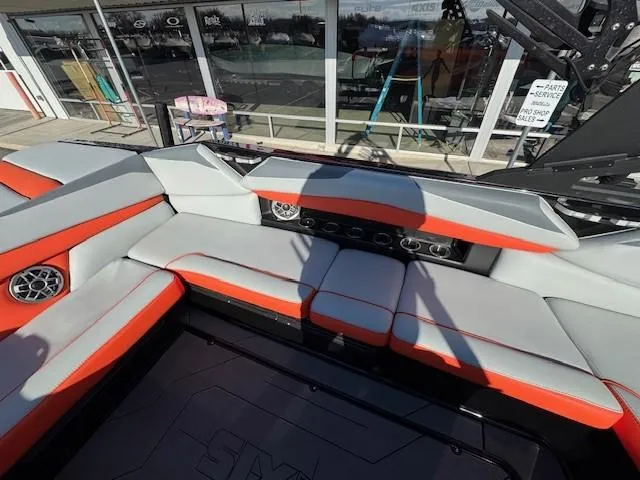 Slide: The Image of 2019 Axis A24 boat interior with red and gray seating, stereo system, and outdoor view. - 17