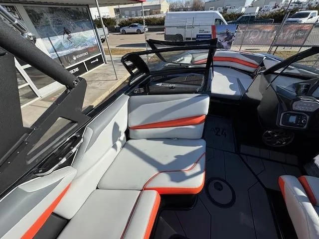 Slide: The Image of 2019 Axis A24 boat interior with gray and orange seating, dashboard, and open windshield. - 19