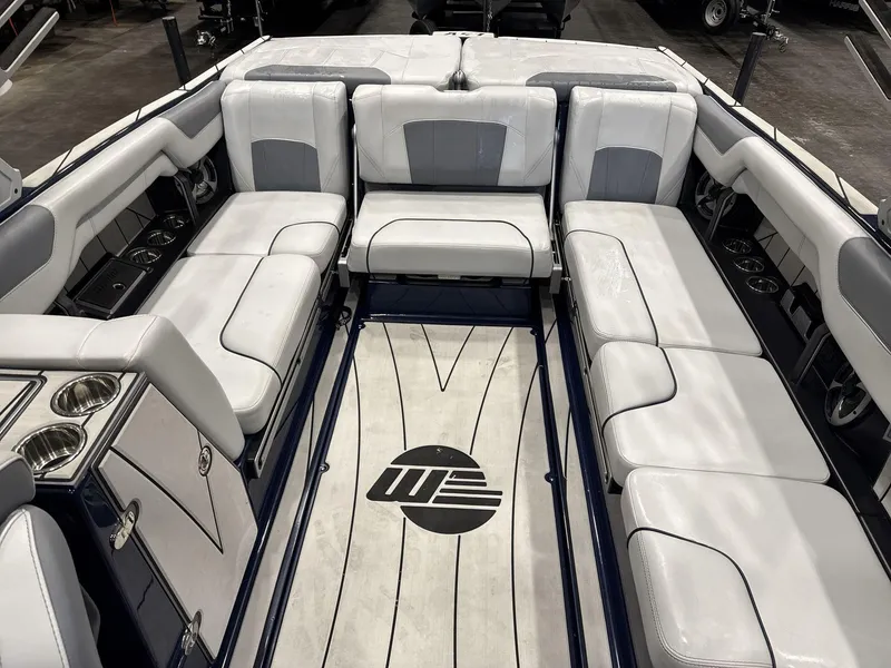 Slide: The Image of 2021 Malibu 25 LSV boat interior with white seating and cup holders. - 12