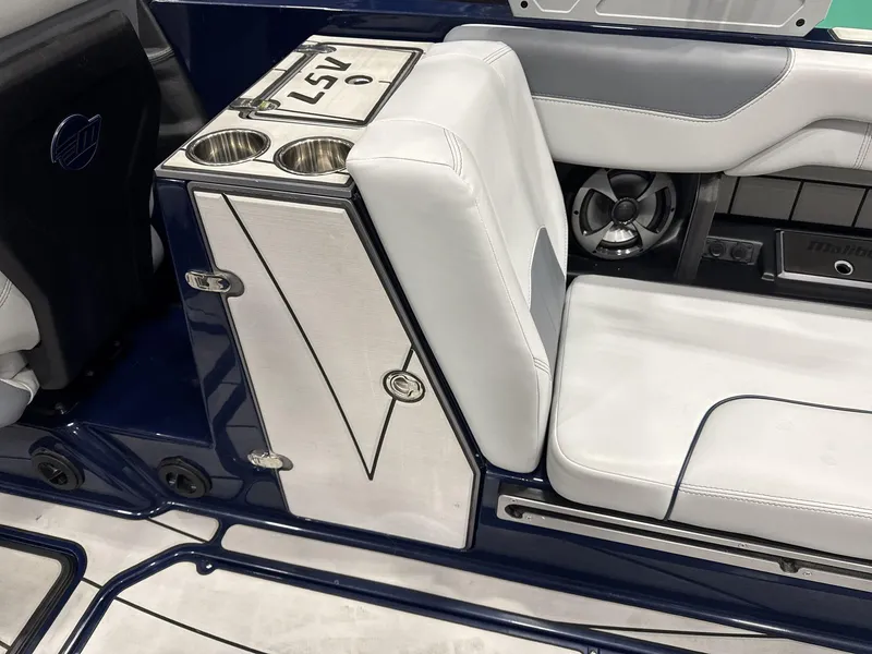 Slide: The Image of 2021 Malibu 25 LSV boat interior with white seating and cup holders. - 13