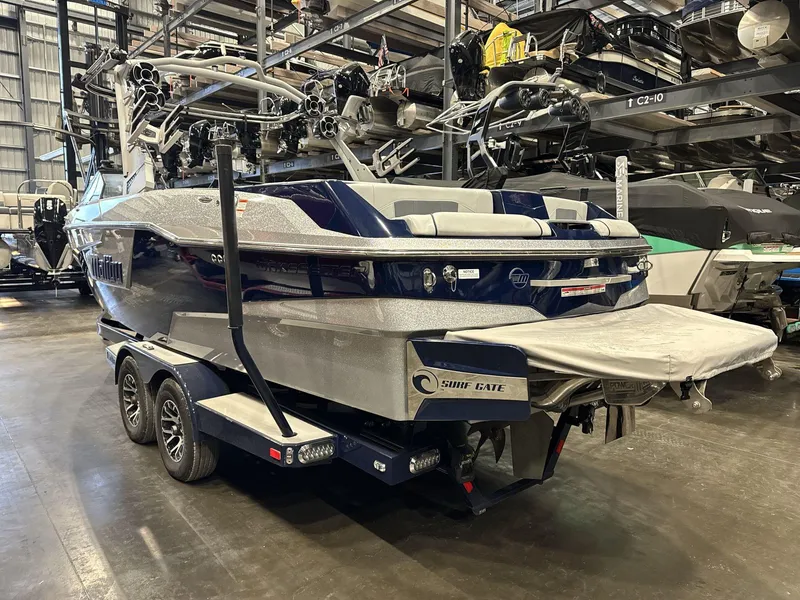 Slide: The Image of 2021 Malibu 25 LSV boat in storage, featuring Surf Gate technology. - 3