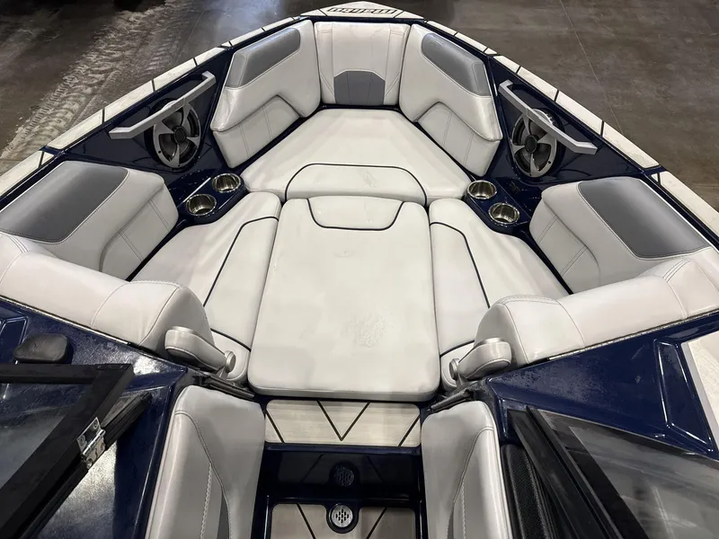Slide: The Image of 2021 Malibu 25 LSV boat interior with white cushioned seating and cup holders. - 7