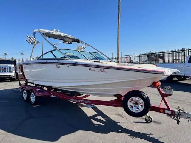 Slide: The Image of 2006 MasterCraft X45 boat on trailer, parked outdoors under clear blue sky. - 4
