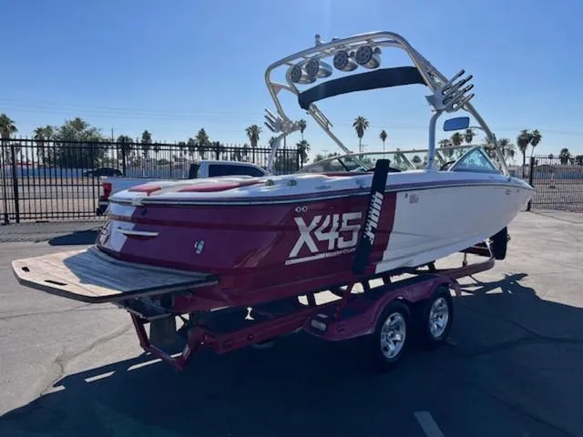 Slide: The Image of 2006 MasterCraft X45 boat on trailer, parked outdoors, with palm trees in background. - 6