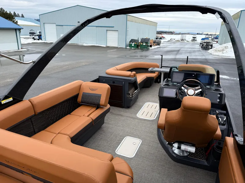 Slide: The Image of 2025 Bennington 24MSB pontoon boat interior with luxurious tan seating and modern dashboard. - 10