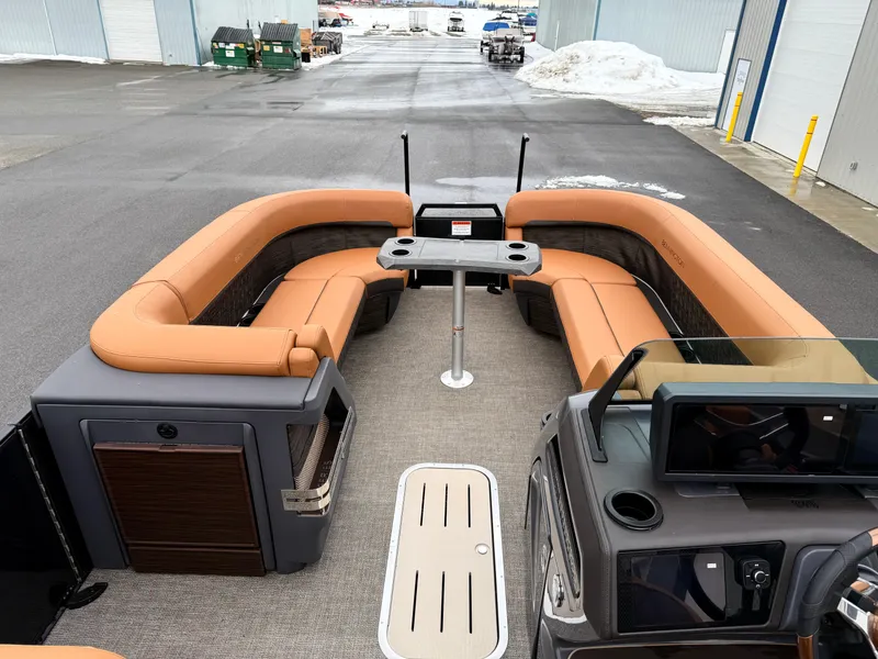 Slide: The Image of 2025 Bennington 24MSB pontoon boat with tan seating and modern interior design. - 12
