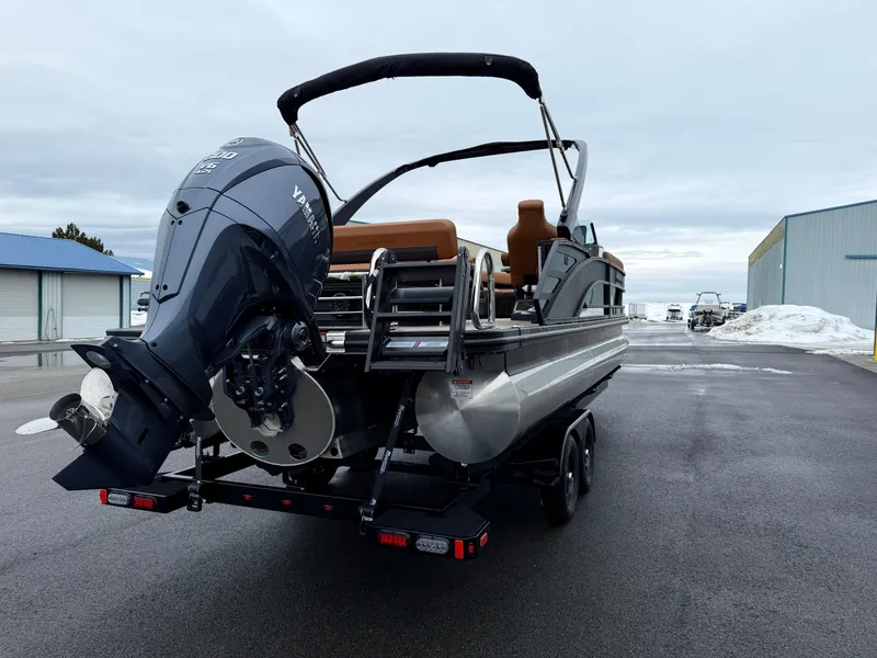 Slide: The Image of 2025 Bennington 24MSB pontoon boat with Yamaha outboard motor on trailer, parked outdoors. - 6