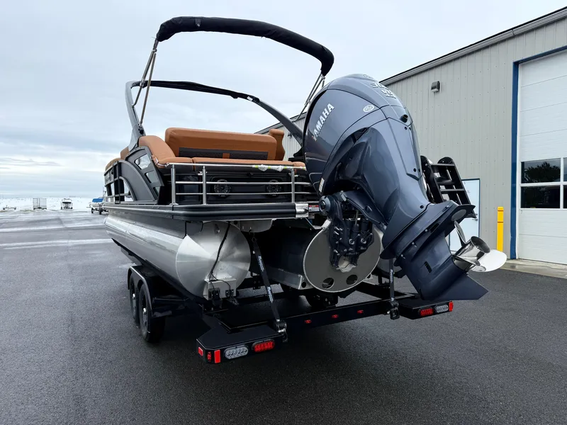Slide: The Image of 2025 Bennington 24MSB pontoon boat with Yamaha outboard motor, parked on a trailer. - 7