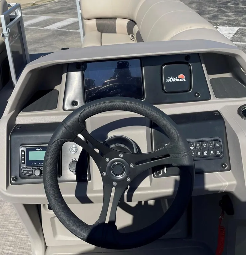 Slide: The Image of 2025 Sun Tracker Party Barge 22 DLX dashboard with steering wheel and controls. - 2