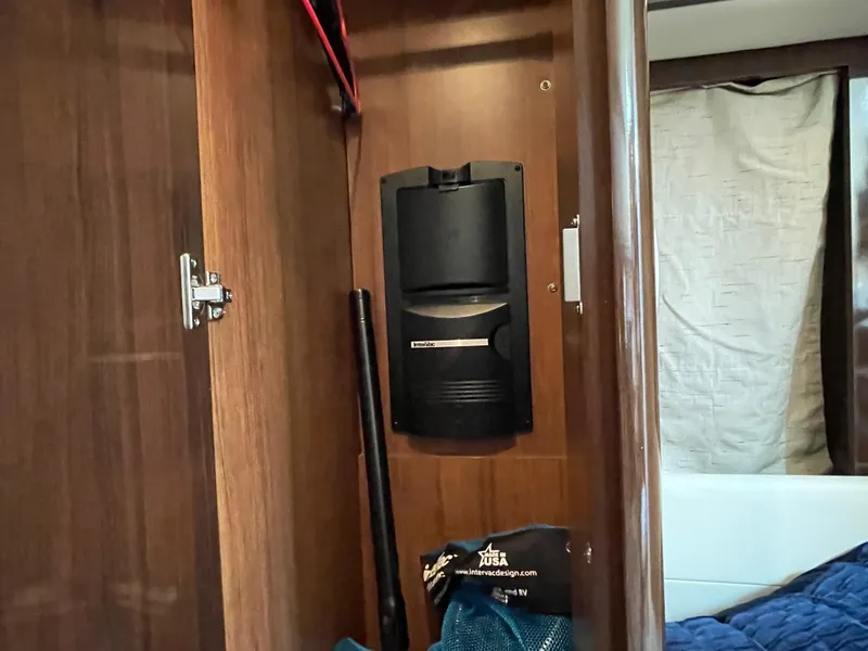 Slide: The Image of Interior of 2015 Sea Ray 350 Sundancer showing a storage compartment with a mounted device. - 12