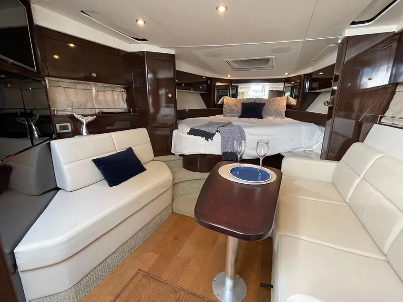 Slide: The Image of 2015 Sea Ray 350 Sundancer interior with elegant seating and cozy bed. - 2