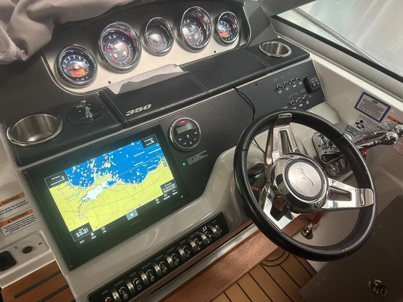 Slide: The Image of Cockpit of 2015 Sea Ray 350 Sundancer with navigation display and steering wheel. - 7
