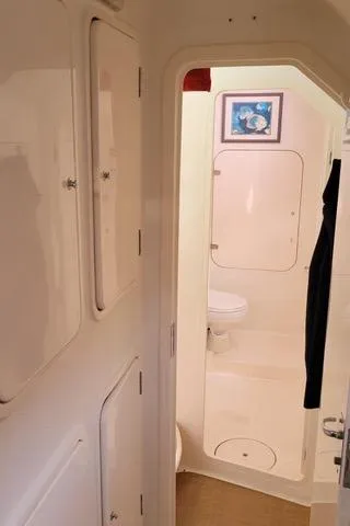 Slide: The Image of Compact bathroom interior of 2001 Voyage Maxim yacht with white fixtures and wall art. - 15