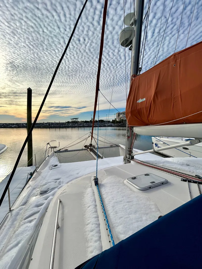 Slide: The Image of Sailboat "Voyage Maxim" 2001 docked at sunset with snowy deck and orange sail. - 19