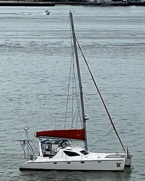 Slide: The Image of Sailboat on water, 2001 Voyage Maxim model, featuring a red sail and sleek design. - 2