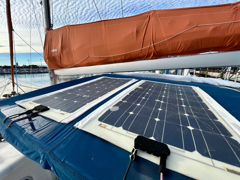 Slide: The Image of Solar panels on a 2001 Voyage Maxim sailboat with orange sail cover. - 20