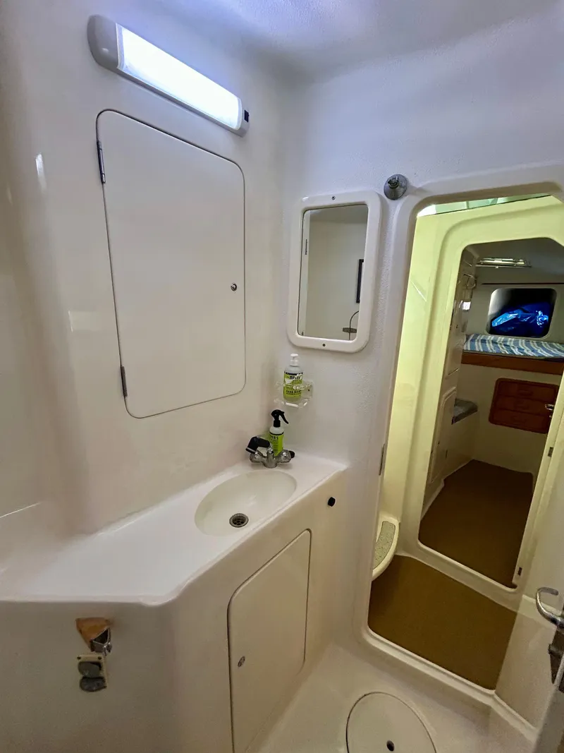 Slide: The Image of 2001 Voyage Maxim yacht bathroom with sink, mirror, and storage compartments. - 21