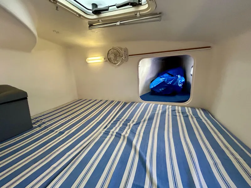 Slide: The Image of Cozy cabin interior of 2001 Voyage Maxim with striped bedding and porthole view. - 24