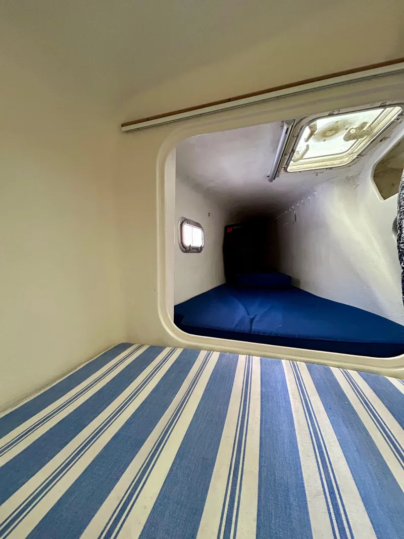 Slide: The Image of Interior cabin of 2001 Voyage Maxim yacht with striped bedding and porthole window. - 30