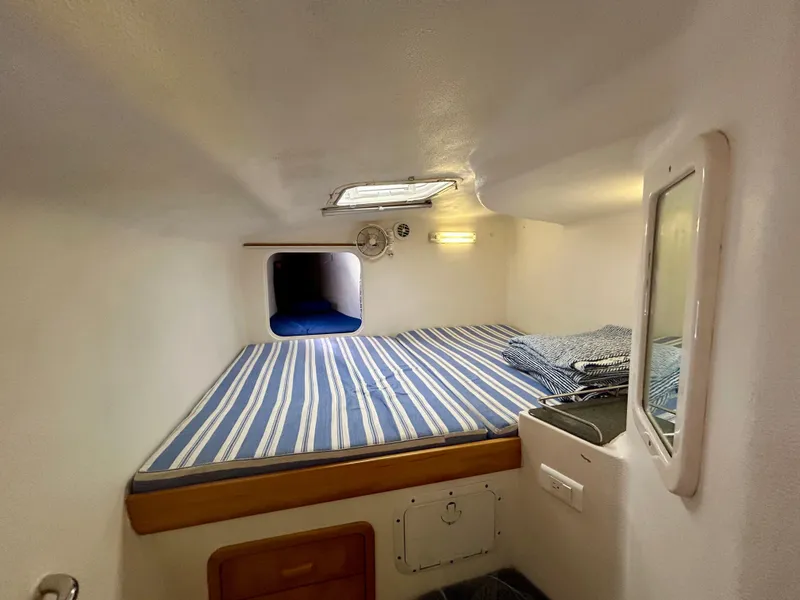 Slide: The Image of Compact cabin interior of 2001 Voyage Maxim with striped bedding and small window. - 31