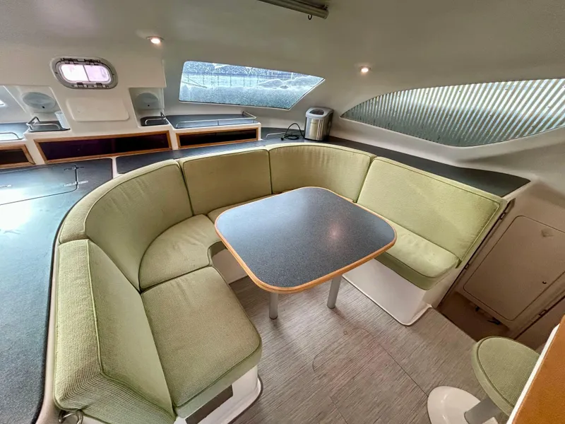Slide: The Image of Spacious interior of 2001 Voyage Maxim yacht with green seating and dining table. - 34