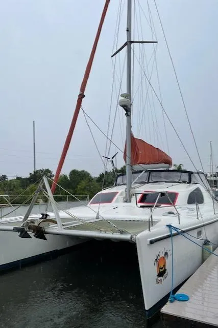 Slide: The Image of 2001 Voyage Maxim catamaran docked, featuring red sail and sleek design. - 4