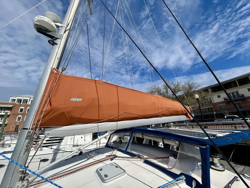 Slide: The Image of Sailboat with orange sail cover, Voyage Maxim 2001, docked under blue sky. - 44