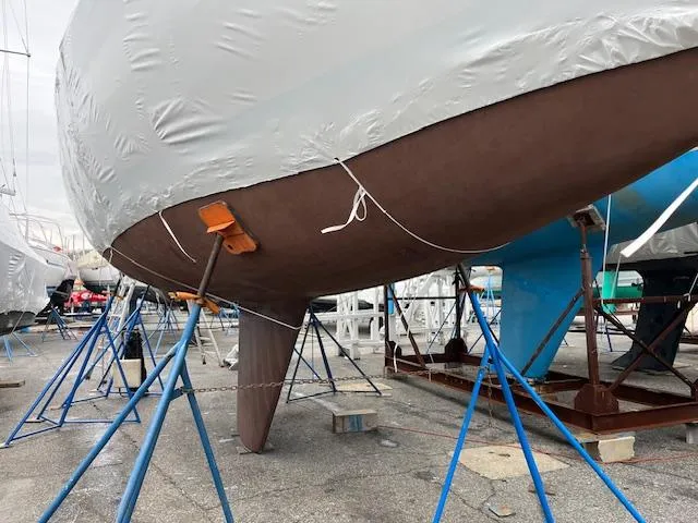 Slide: The Image of 1983 Sabre 38 sailboat on stands, covered for maintenance in a boatyard. - 13