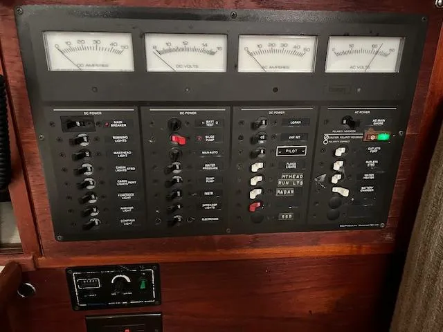 Slide: The Image of Electrical control panel on a 1983 Sabre 38 boat, featuring various switches and gauges. - 25