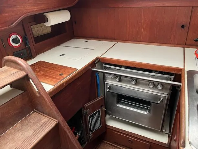 Slide: The Image of 1983 Sabre 38 yacht interior kitchen with stove and wooden cabinetry. - 26