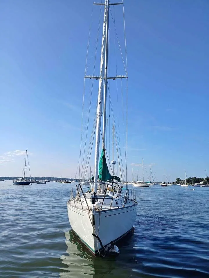 Slide: The Image of 1983 Sabre 38 sailboat on calm water, clear blue sky background. - 3