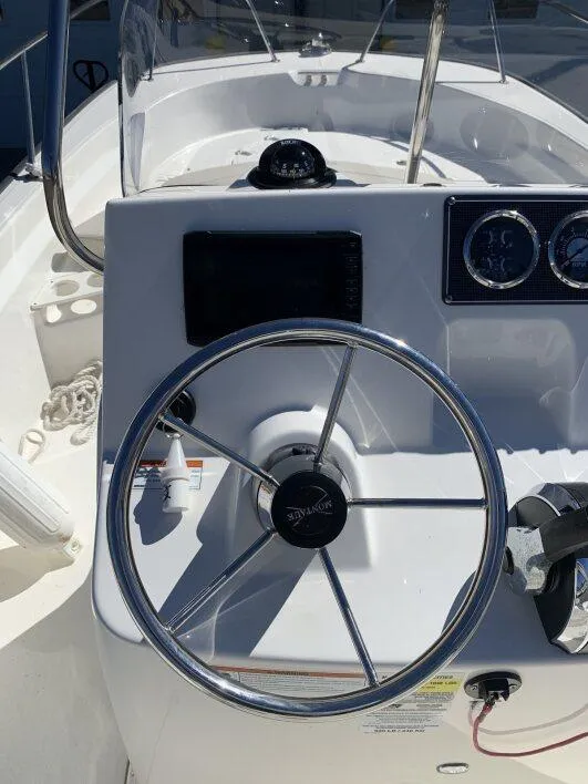 Slide: The Image of 2024 Boston Whaler 190 Montauk steering console with chrome wheel and gauges. - 2