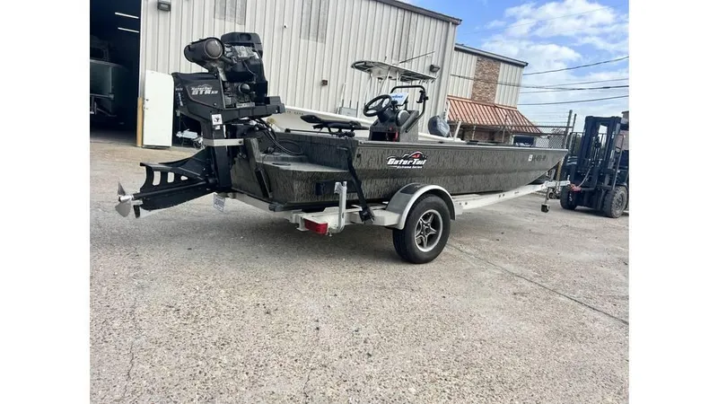 Slide: The Image of 2022 Gator Tail 1860 boat on trailer, parked outside a warehouse. - 10