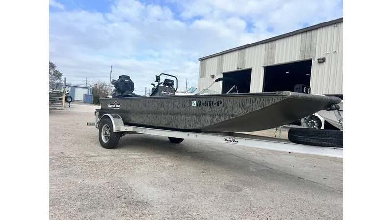 Slide: The Image of 2022 Gator Tail 1860 boat on trailer outside industrial building. - 9