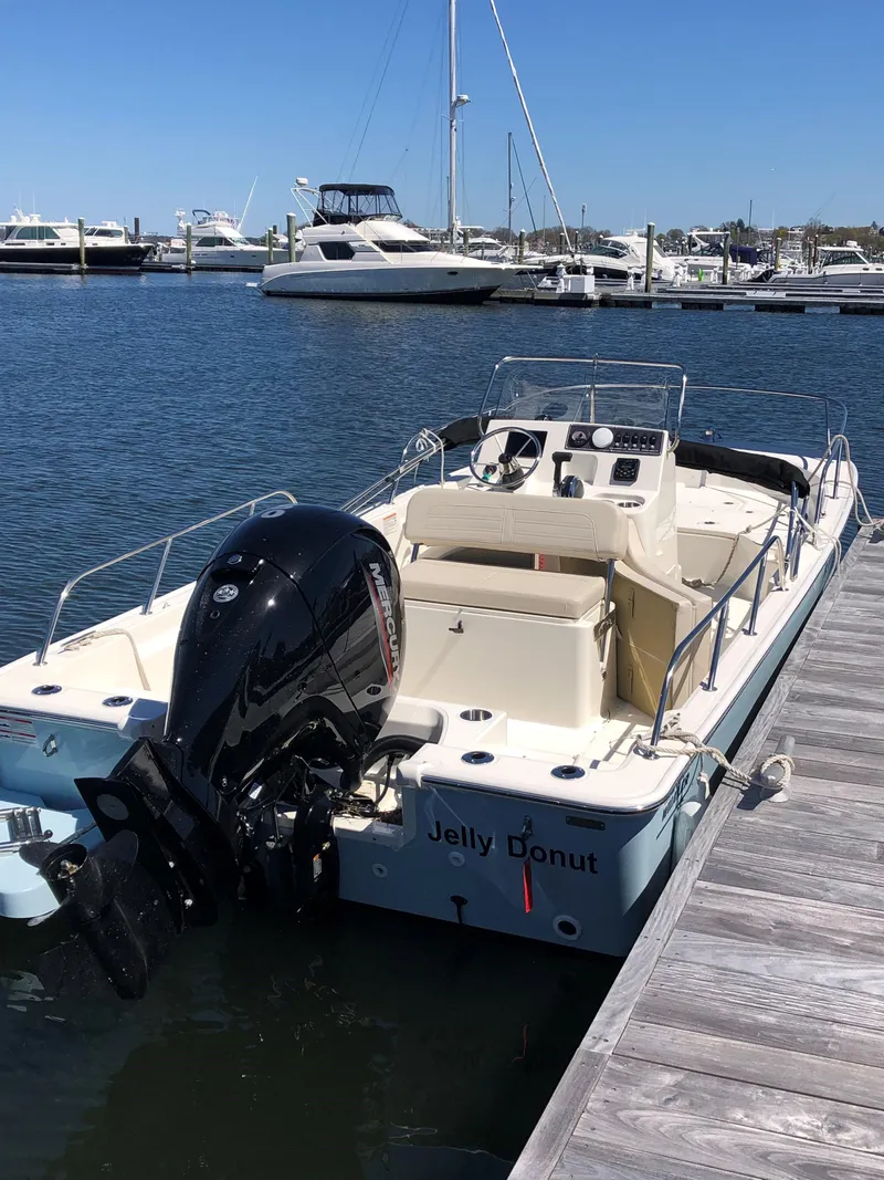 Slide: The Image of 2024 Boston Whaler 190 Montauk boat docked at marina, named "Jelly Donut." - 1