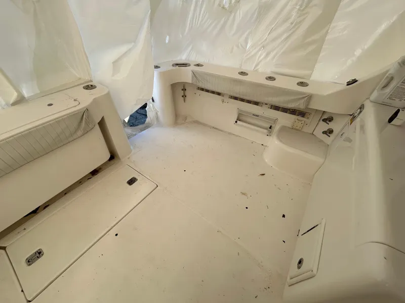 Slide: The Image of 2007 Luhrs 36 Convertible boat interior with white seating and storage compartments. - 10
