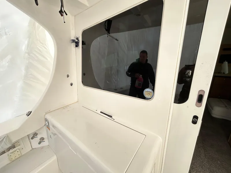 Slide: The Image of 2007 Luhrs 36 Convertible boat interior with window and cleaning supplies. - 12