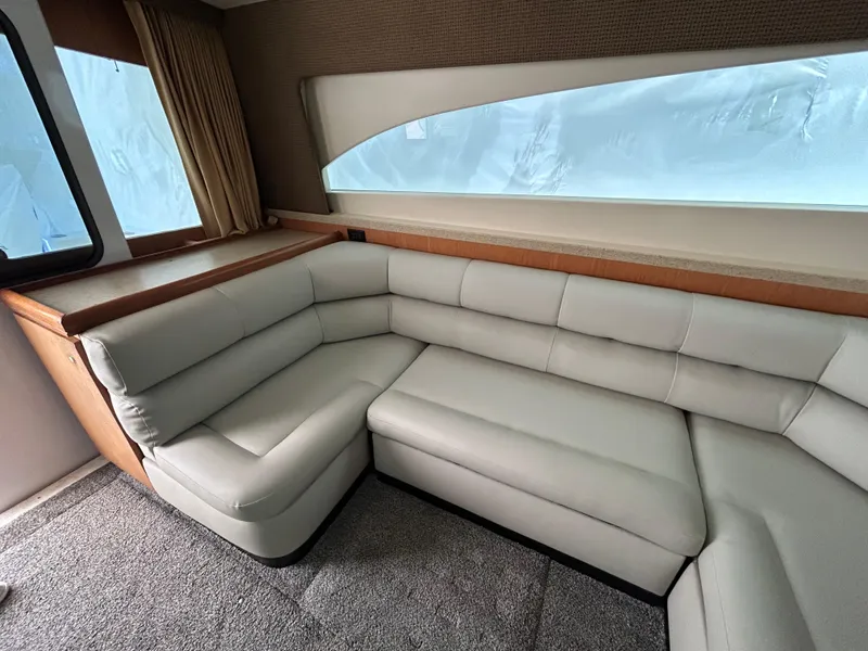Slide: The Image of 2007 Luhrs 36 Convertible yacht interior with plush L-shaped seating and large window. - 13