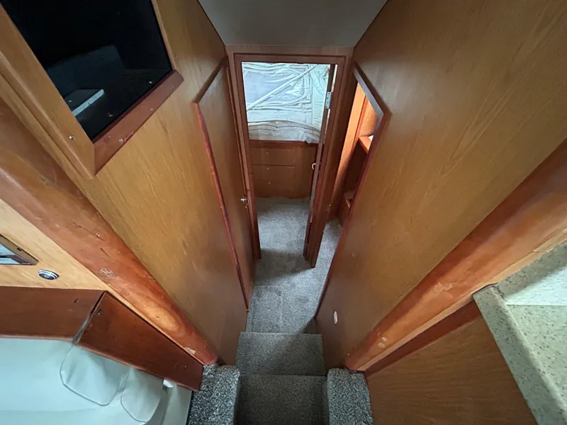Slide: The Image of 2007 Luhrs 36 Convertible interior hallway with wooden paneling and carpeted stairs. - 17