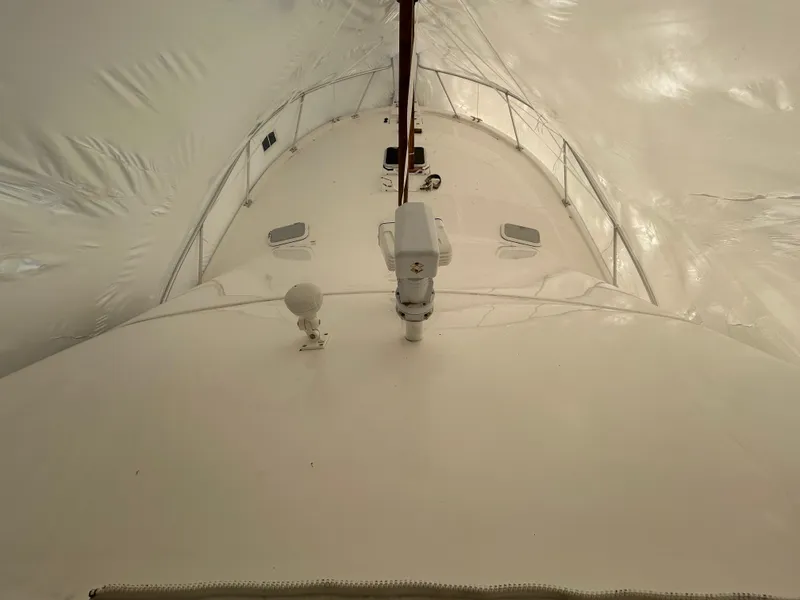 Slide: The Image of 2007 Luhrs 36 Convertible yacht under protective cover, showcasing deck and equipment. - 5