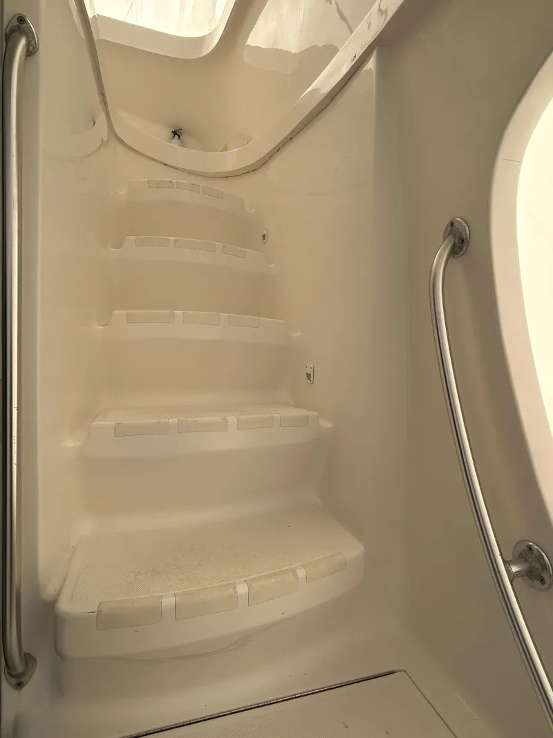 Slide: The Image of Staircase inside 2007 Luhrs 36 Convertible boat, featuring white steps and metal handrails. - 8