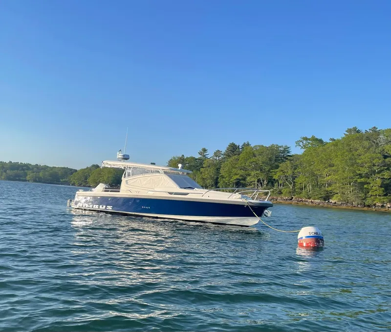 Slide: The Image of Nimbus W9 2023 boat on calm water near a forested shoreline. - 10