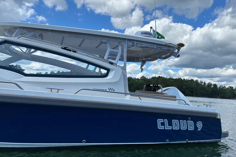 Slide: The Image of 2023 Nimbus W9 boat named "Cloud 9" on a lake under a cloudy sky. - 14